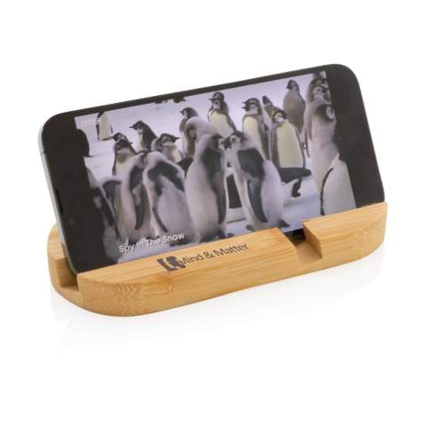 Support de téléphone en bambou entièrement naturel. Parfait sur votre bureau ou lorsque vous travaillez de la maison. Le support peut accueillir la plupart des appareils mobiles et des tablettes. Le sillon plus court est optimisé pour les téléphones portables et le plus long pour les tablettes.