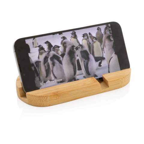 Support de téléphone en bambou entièrement naturel. Parfait sur votre bureau ou lorsque vous travaillez de la maison. Le support peut accueillir la plupart des appareils mobiles et des tablettes. Le sillon plus court est optimisé pour les téléphones portables et le plus long pour les tablettes.