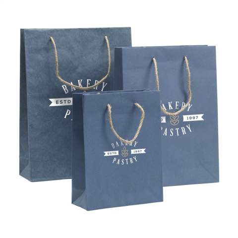 WoW! Stevige ECO geschenktas (maat L) gemaakt van gerecycled papier met jeansvezels (180 g/m²). Door het gebruik van gerecyclede jeansstoffen kan de kleur blauw per tas verschillen. De blauwe kleur geeft de tas een trendy uitstraling. De tas heeft twee korte jute draaglussen, een gevouwen bodem en een zijvouw. Geschikt voor allerlei promotionele doeleinden. Voor de productie van deze tas worden geen  bomen gekapt.