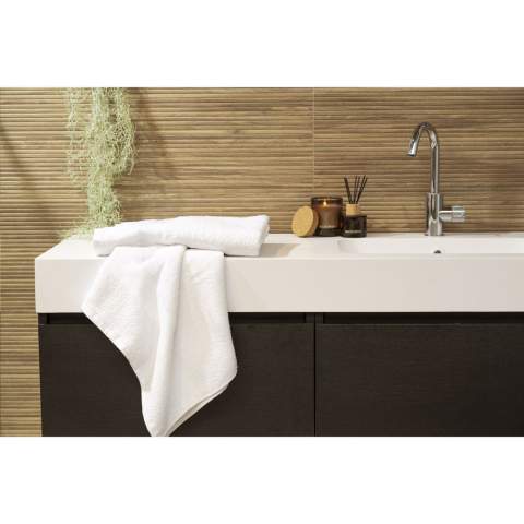 This bath towel from the Wooosh Brand is made from 50% recycled cotton and 50% cotton. The towel has a handy loop and a woven band and is beautifully finished with a cotton trim. The softness of the tightly woven terry gives a feeling of luxury and comfort after an invigorating shower or warm bath. The fibres of the 400 grams of terry cotton are highly moisture-absorbent and feel pleasant on your skin while drying. This bathroom textile has a timeless look and fits into any interior. This product is GRS-certified and produced with special attention paid to people and the environment.