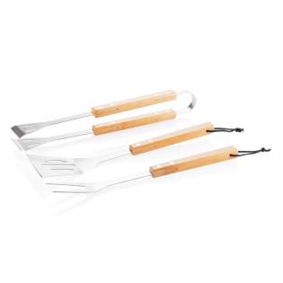 Set d’outils en acier inoxydable avec poignées en bambou. L’ensemble comprend une spatule, une fourchette à viande et une pince.